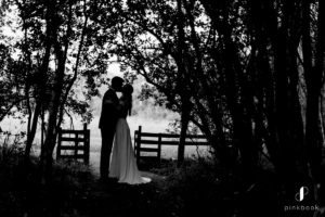 Bride and groom kissing in forest