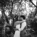 Bride and groom kiss in forest